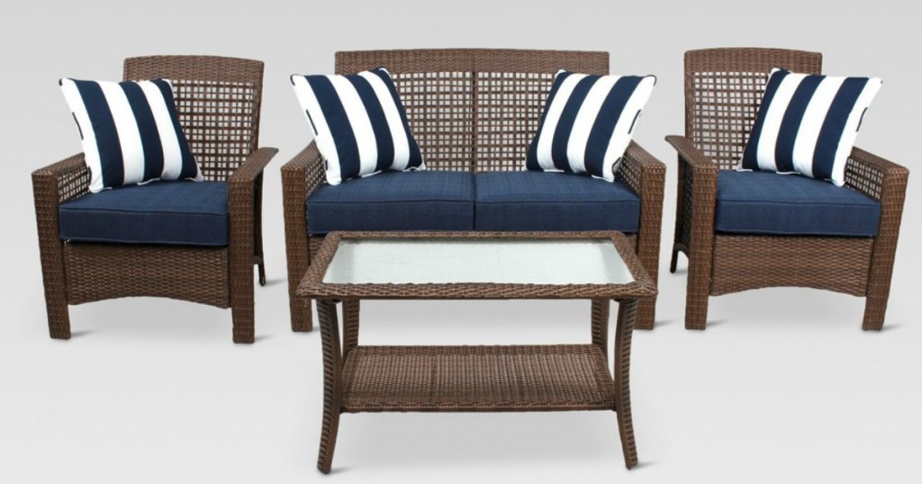 wicker patio set with navy cushions and striped pillows