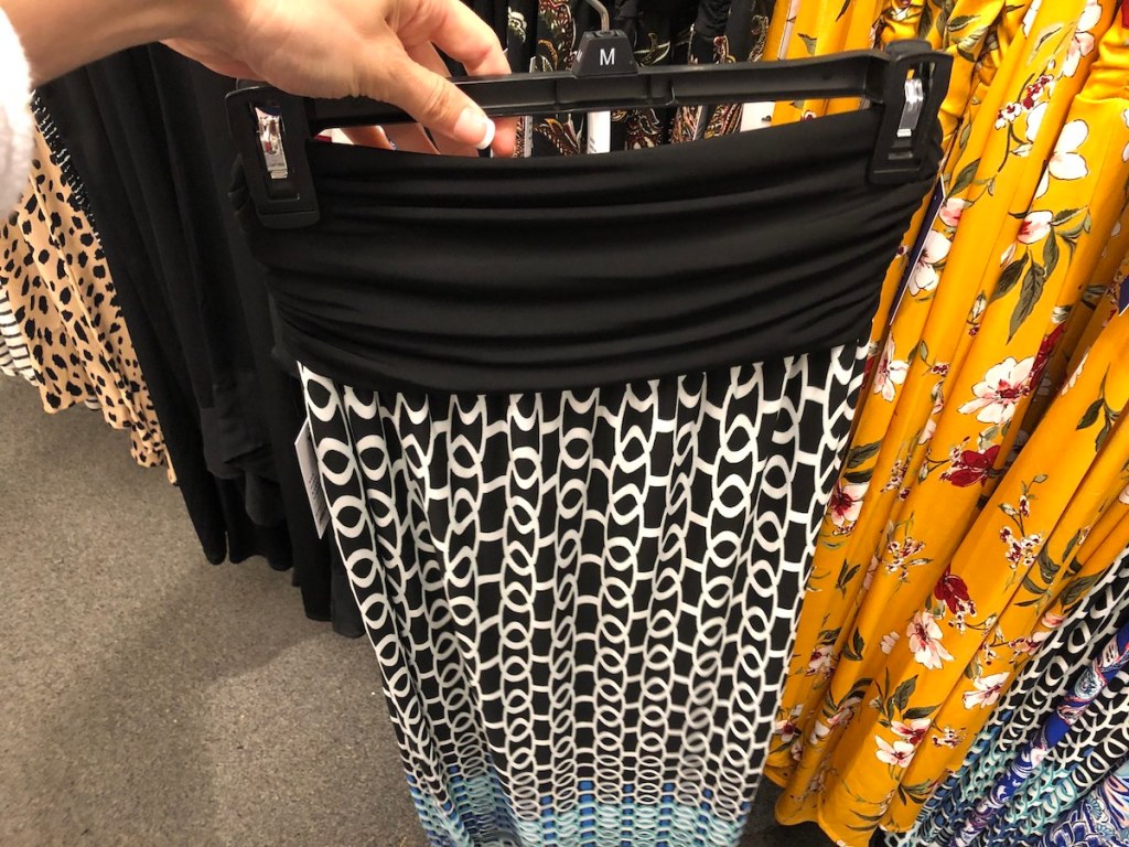 person holding maxi skirt on hanger