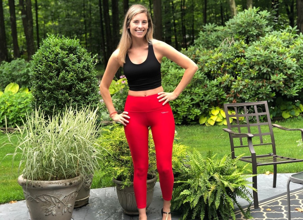 woman wearing red capri and black sports bra swim top