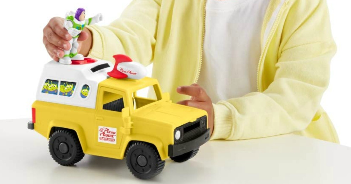 child holding Buzz Lightyear on top of toy Pizza Planet truck