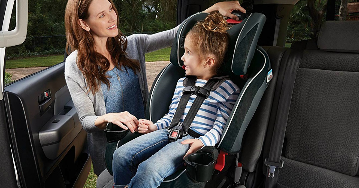 woman adjusting childs car seat