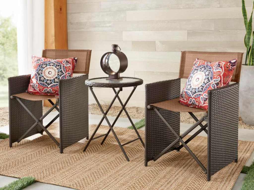 Hampton Bay Montrose 3-Piece Folding Wave Glass Bistro Set with accent pillows on a patio