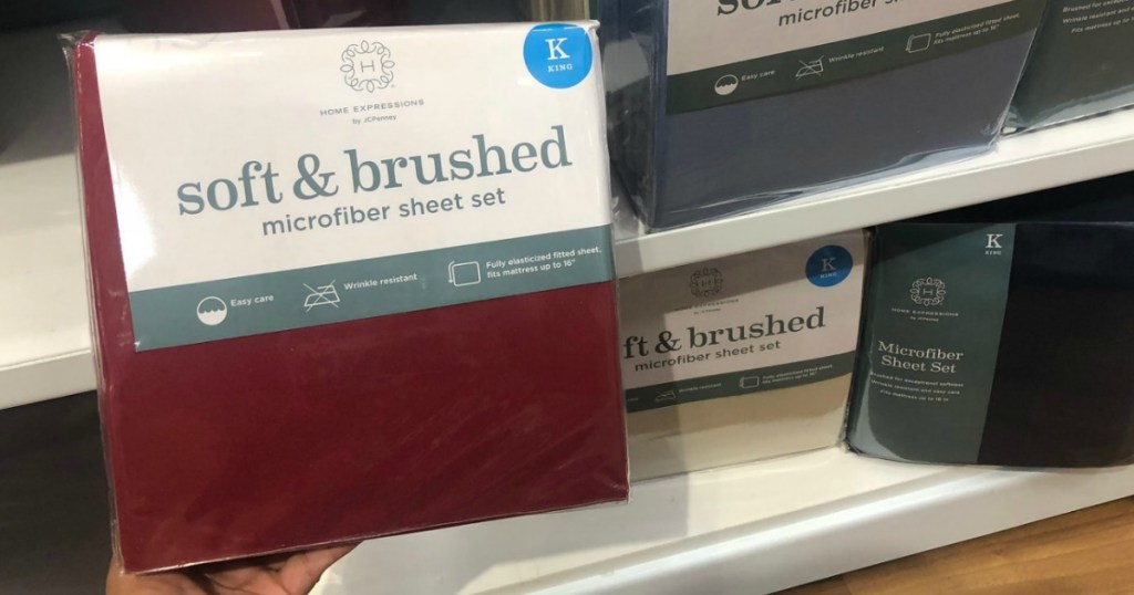 JCPenney brand sheet set in burgundy color in front of shelf of King size sheets