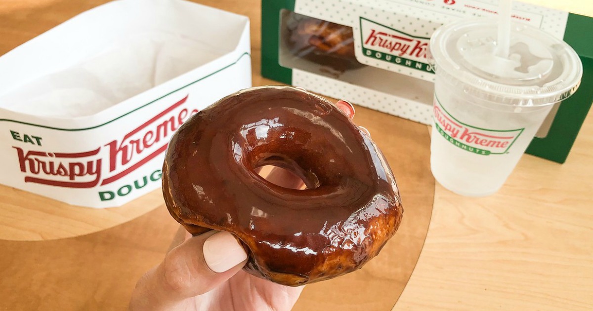 Krispy Kreme Chocolate Glazed with Krispy Kreme hat, box and cup in background