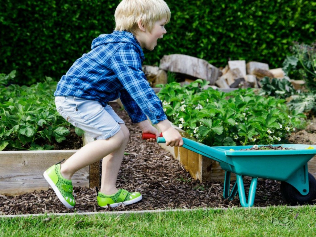 boy helping in garden wearing gator shoes