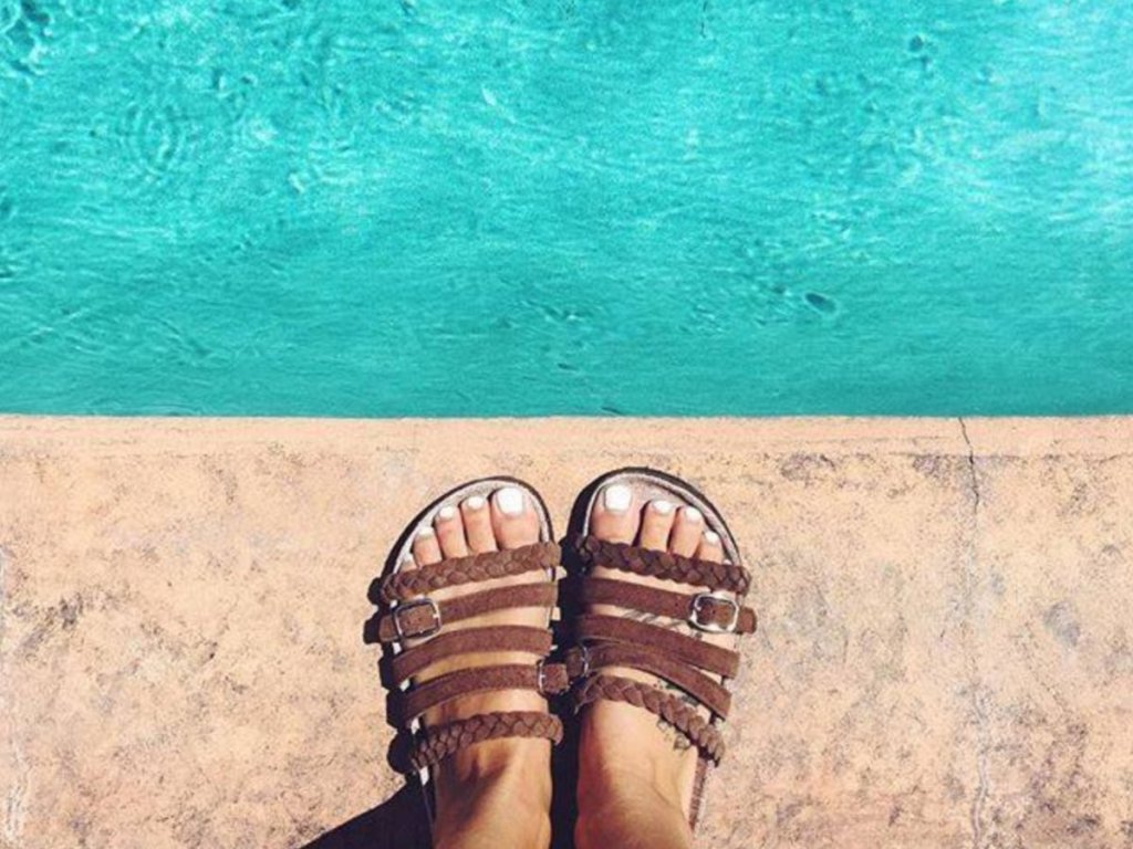 Woman wearing Muk Luks Chocolate Chip Terri Terra Turf Slide Sandals by poolside