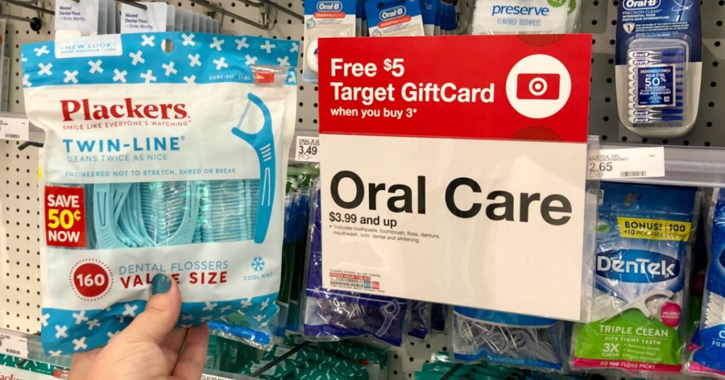 woman holding Plackers Flossers at Target