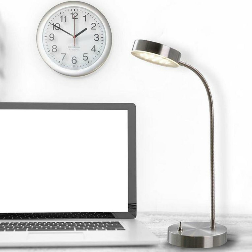 Chrome lamp on desk top with onlineputer and clock