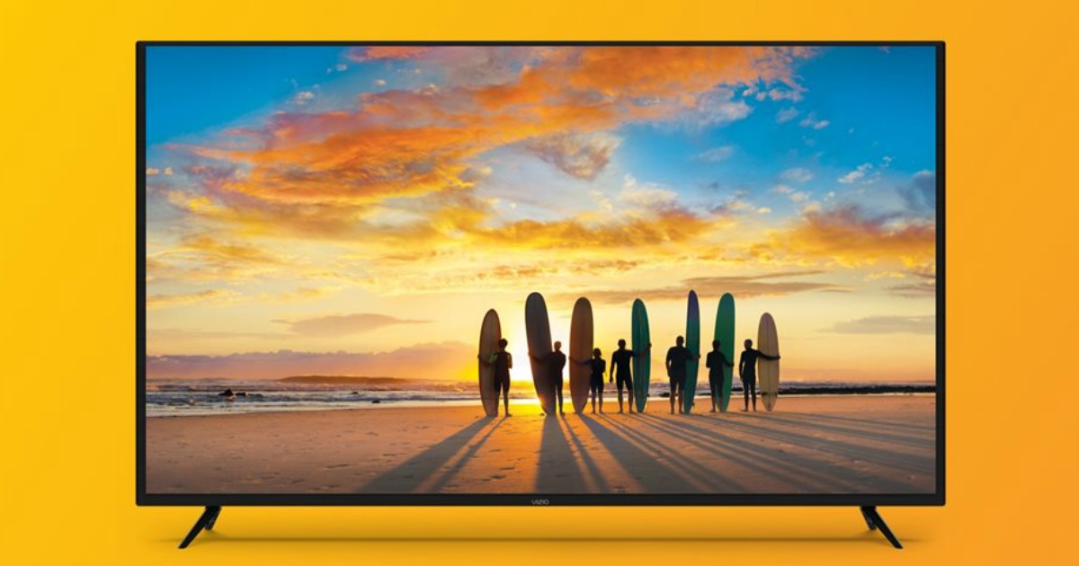 big screen tv showing surfboards and surfboarders on a beach with a beautiful sunset