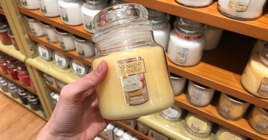 hand holding a vanilla cupcake medium yankee candle jar