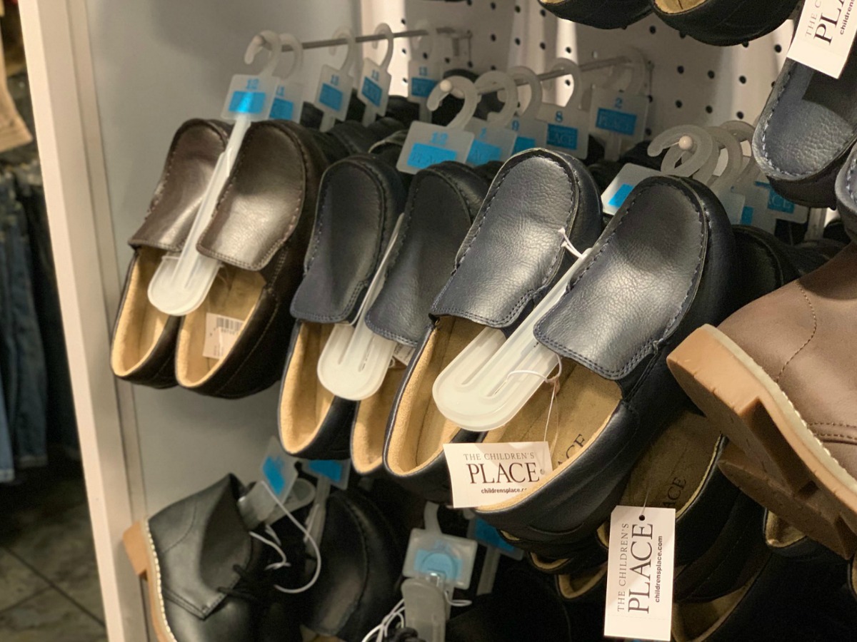 boys dress uniform shoes hanging on store rack