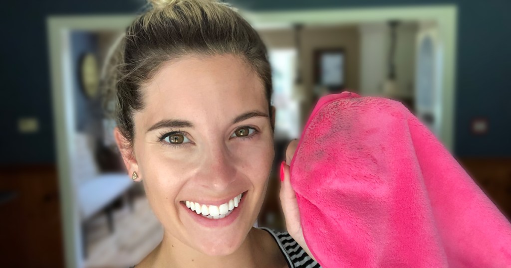 woman holding up used makeup eraser with eye makeup removed