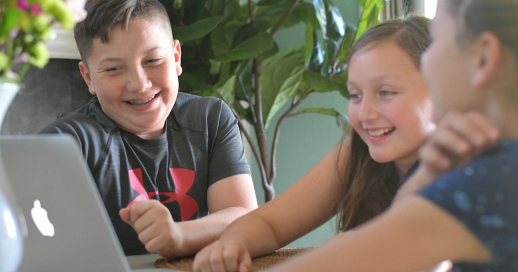 kids laughing while looking at laptop