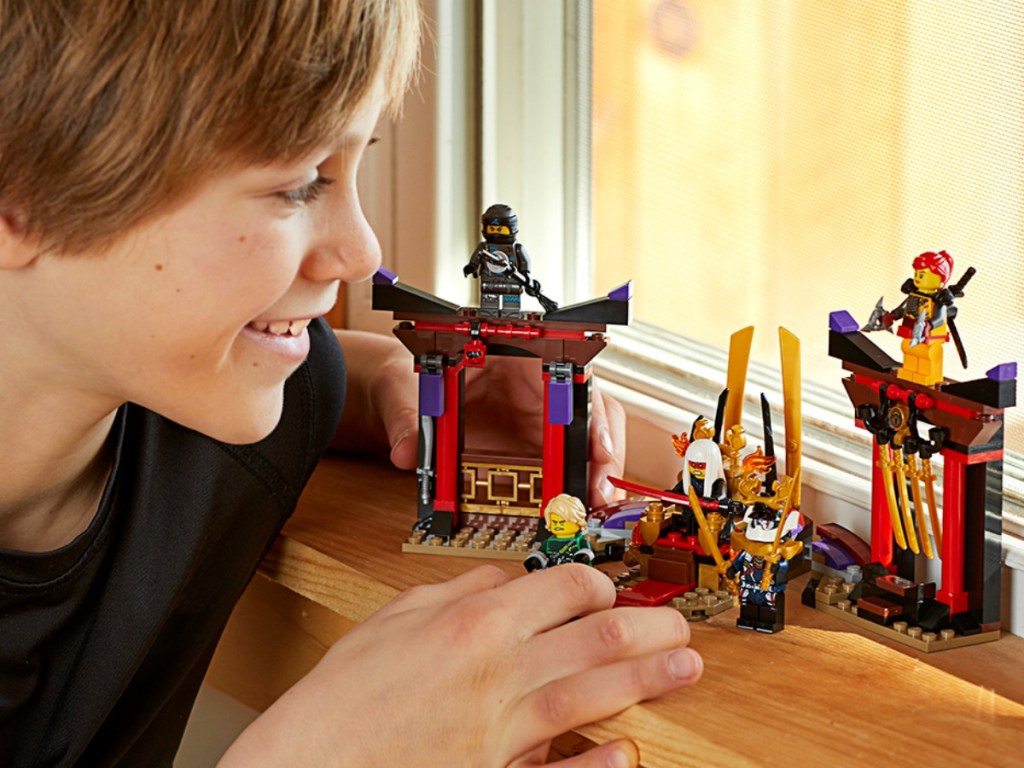 boy playing with legos on window