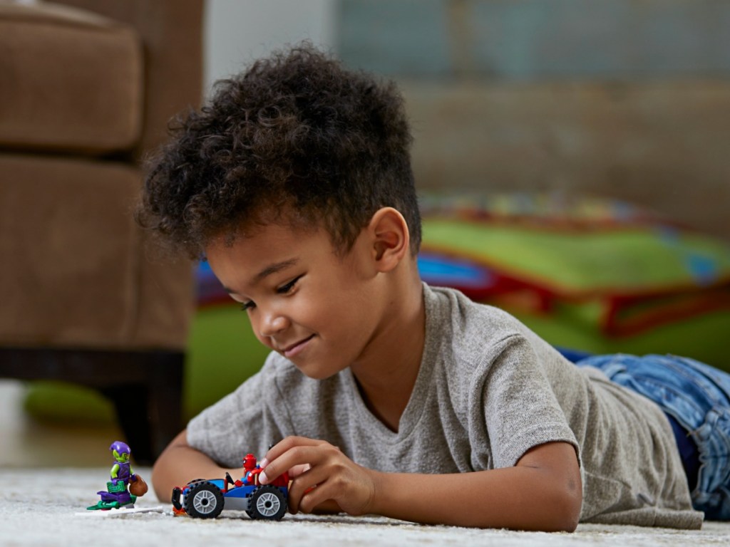 little boy playing with legos on carpeted floor