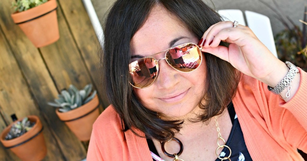 woman wearing orange mirrored sunglasses and orange top outside