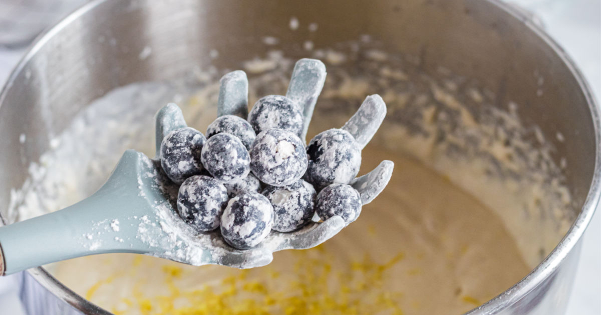 Adding blueberries to the cake batter 