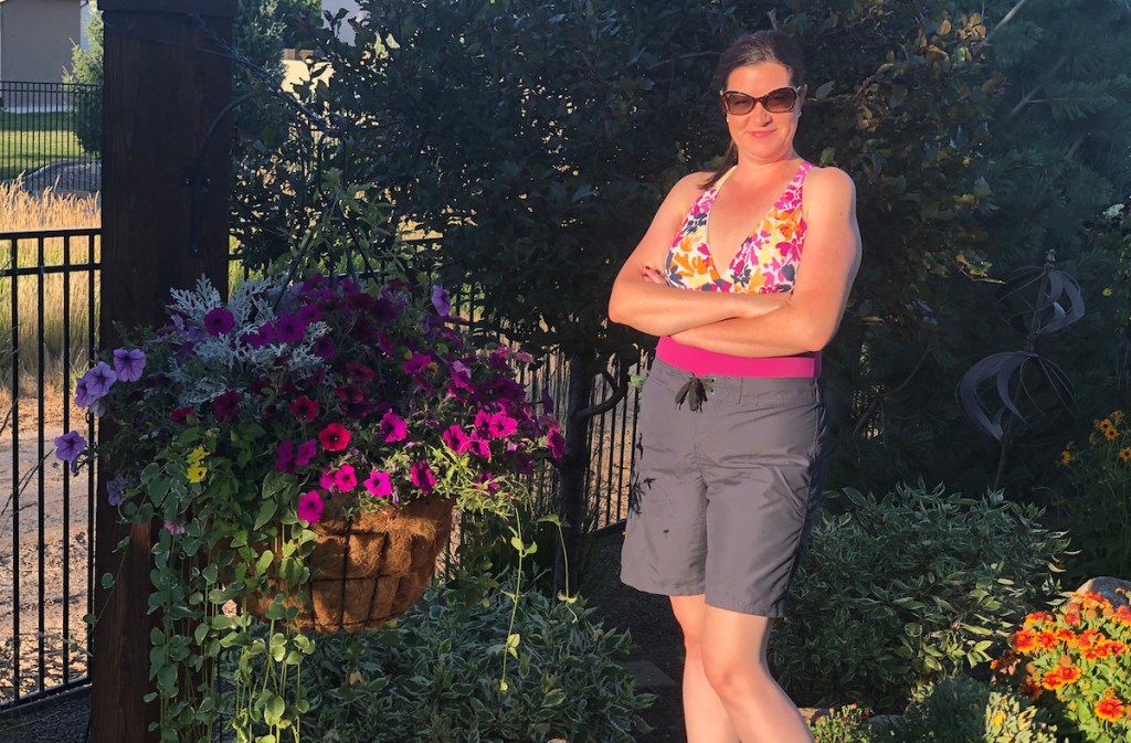 woman wearing bathing suit and gray swim shorts outside