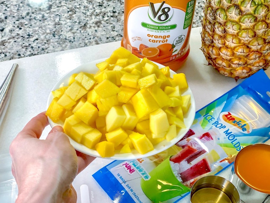 hand holding a bowl of fresh dices mangos