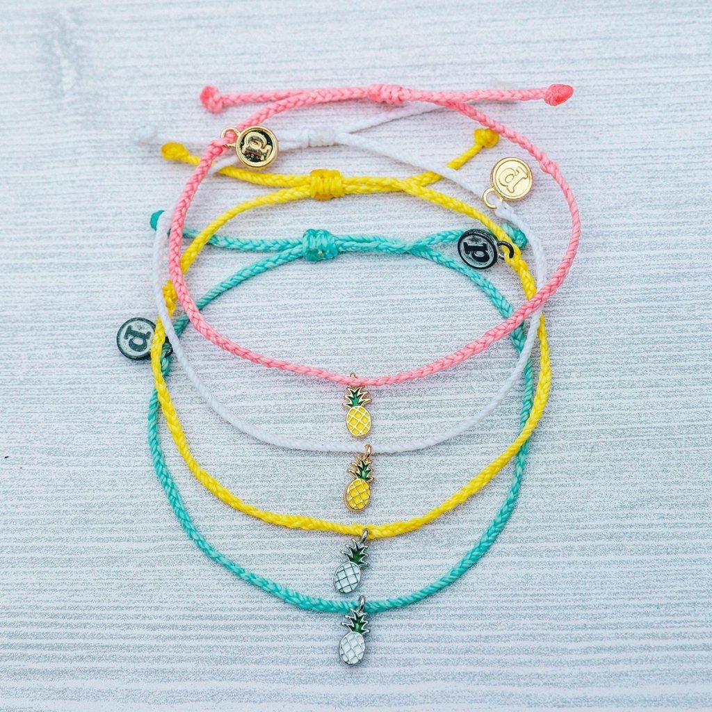 assorted pura vida pineapple charm bracelets stacked together