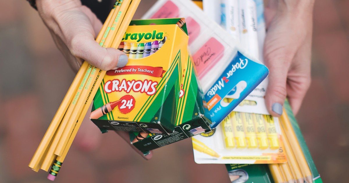 hands holding school supplies