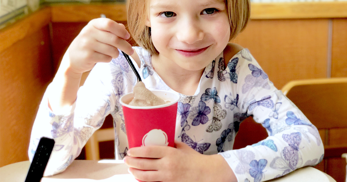 girl eating a Frosty at a Wendy's restaurant