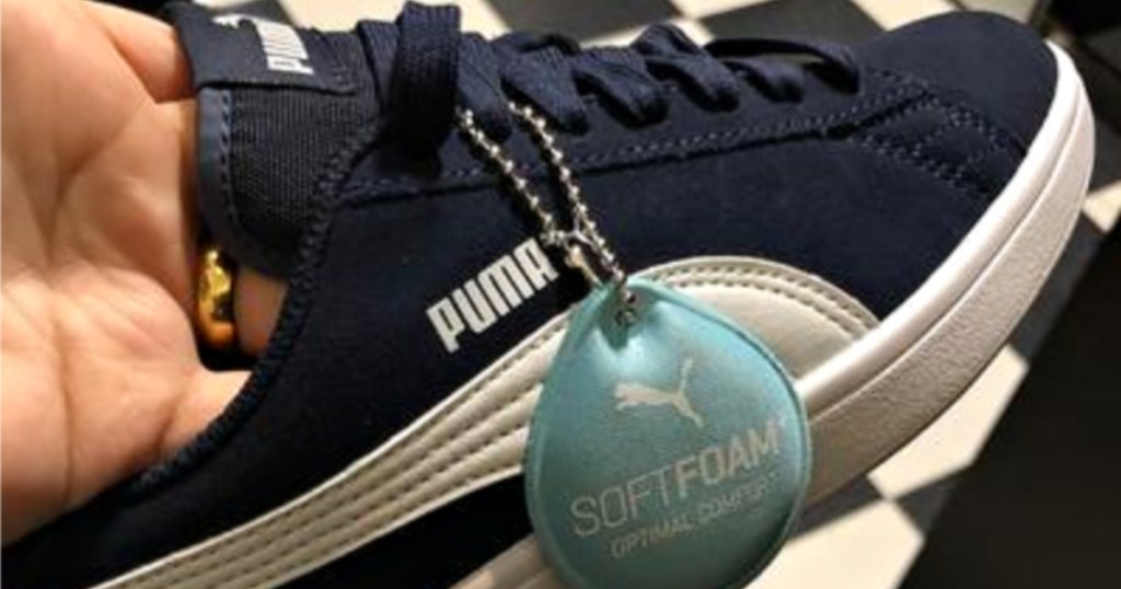 hand holding boys navy blue puma shoes