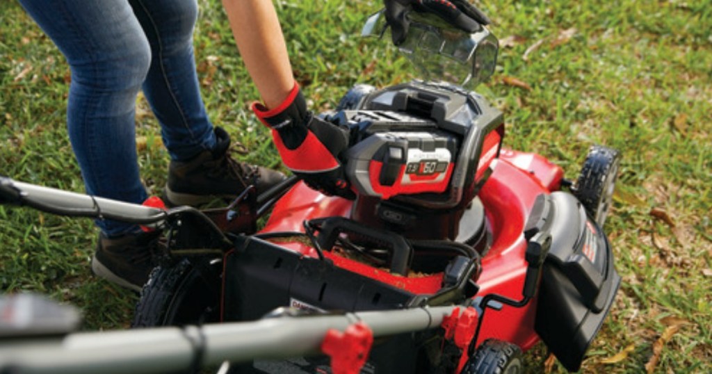 woman putting battery in Craftsman mower