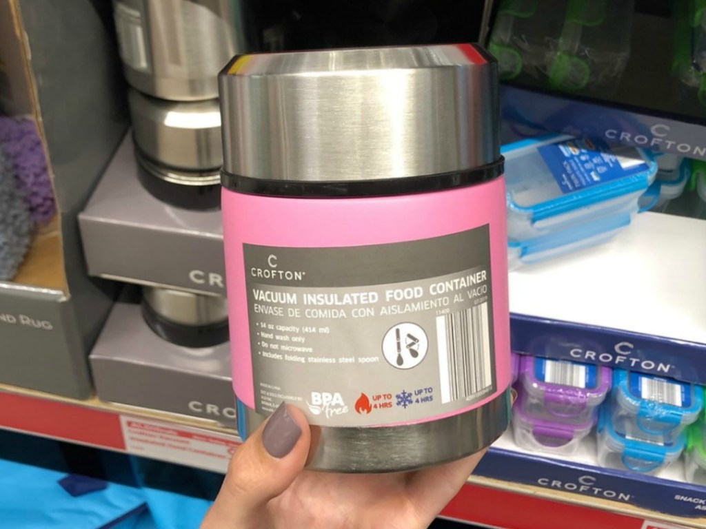 hand holding pink thermos in front of store display