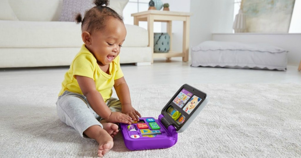 baby girl playing with Fisher-Price toy laptop