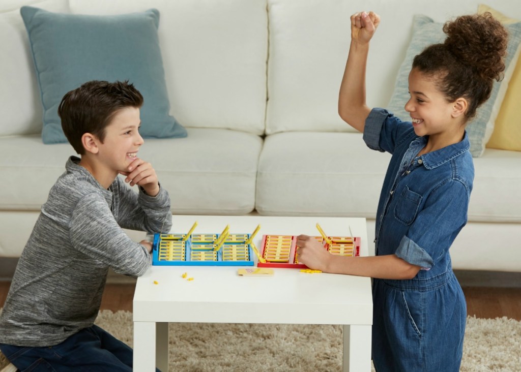 boy and girl playing Guess Who? game at small table