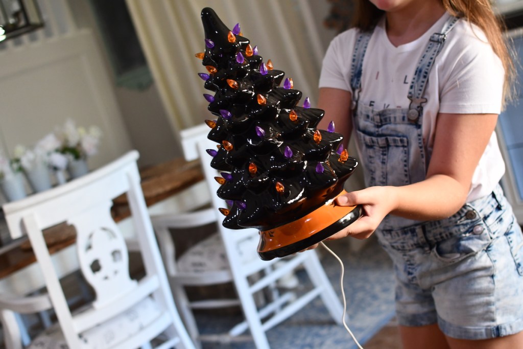 Girl holding ceramic Halloween Tree