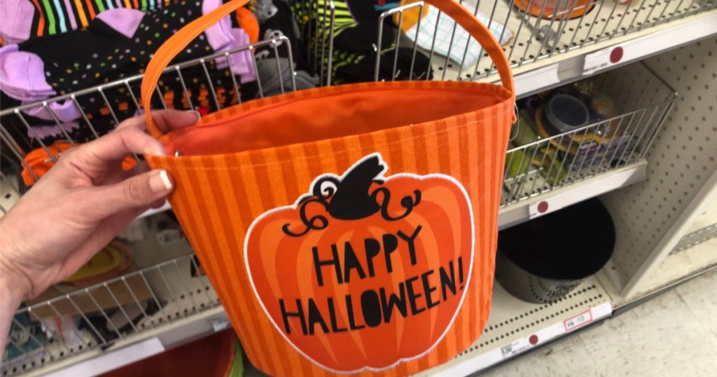 woman holding up halloween candy bucket at target