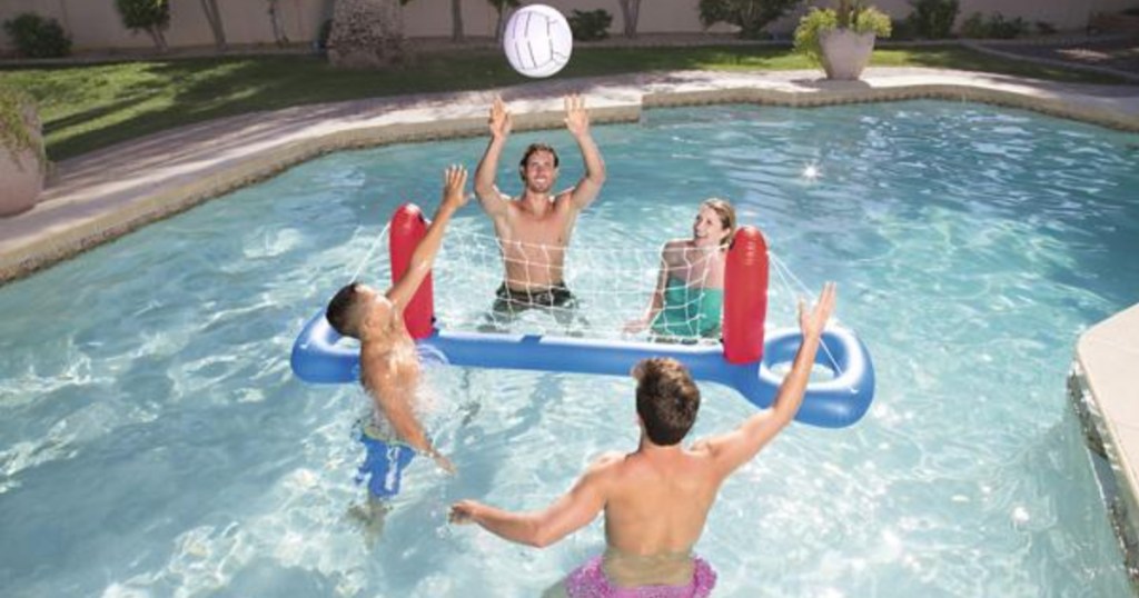 people playing in pool with inflatable volleyball net