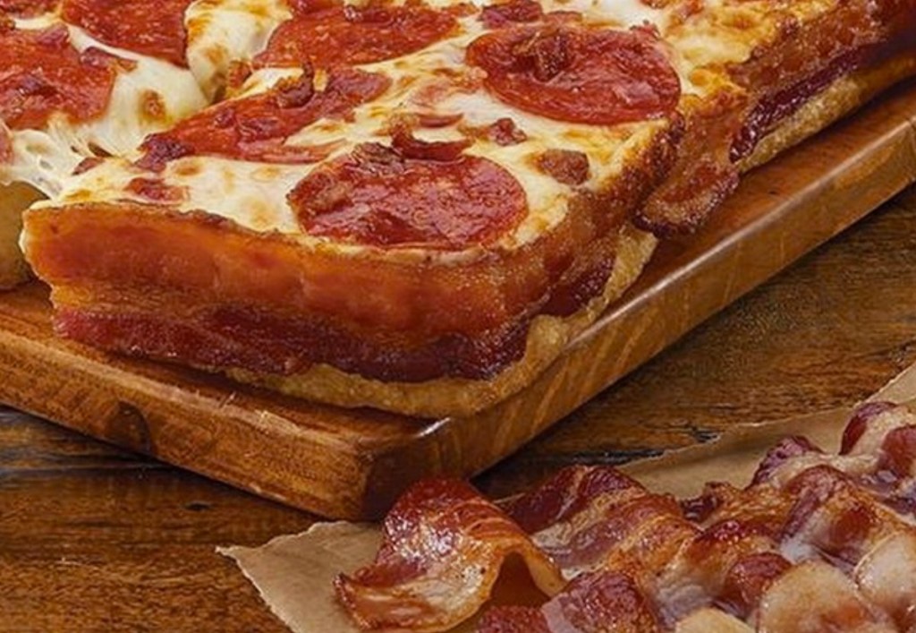 Close up view of a bacon wrapped deep dish pizza