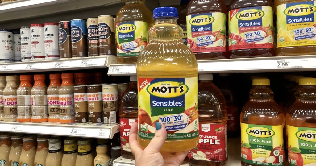 woman holding bottle of motts sensible apple juice at target