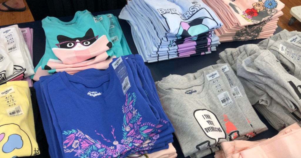 folded oshkosh shirts on table at store