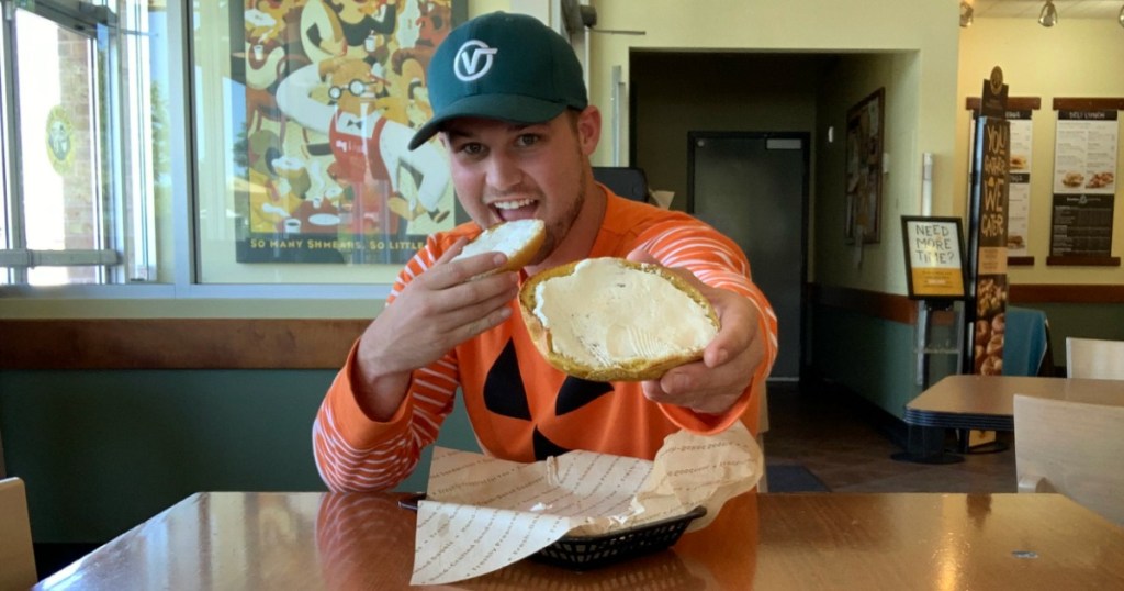 Man holding Pumpkin Bagel in Einstein Bros. Bagels