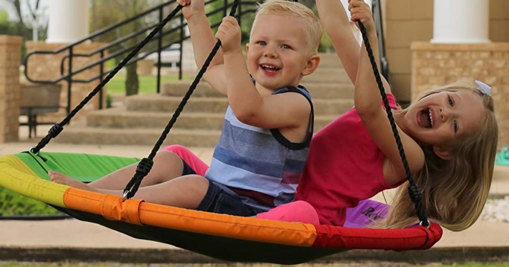 Boy and girl swinging on rainbow royal oak Flying Saucer Tree Swing