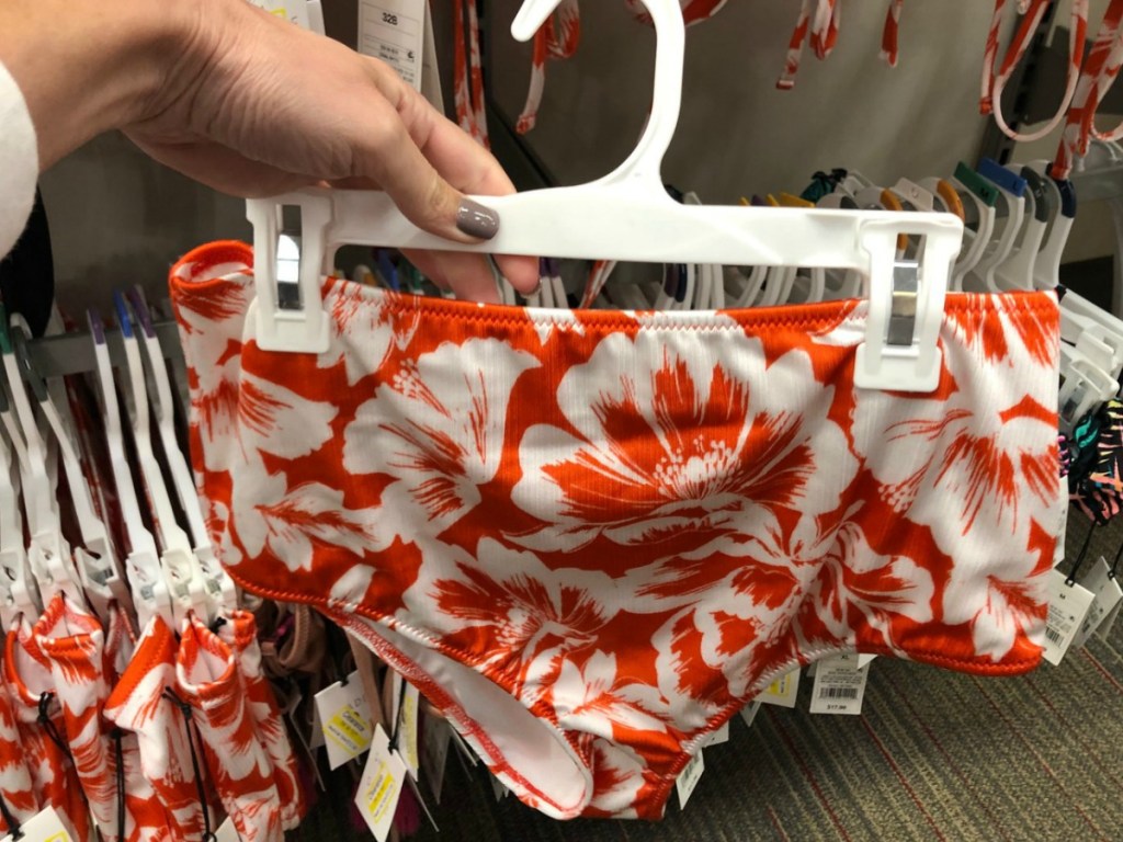 hand holding orange bikini bottom in store