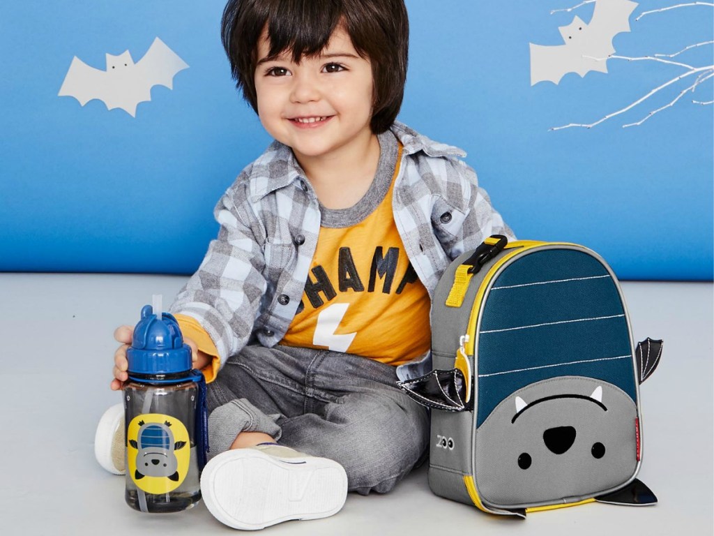 boy sittingnext to Skip Hop Bat Backpack