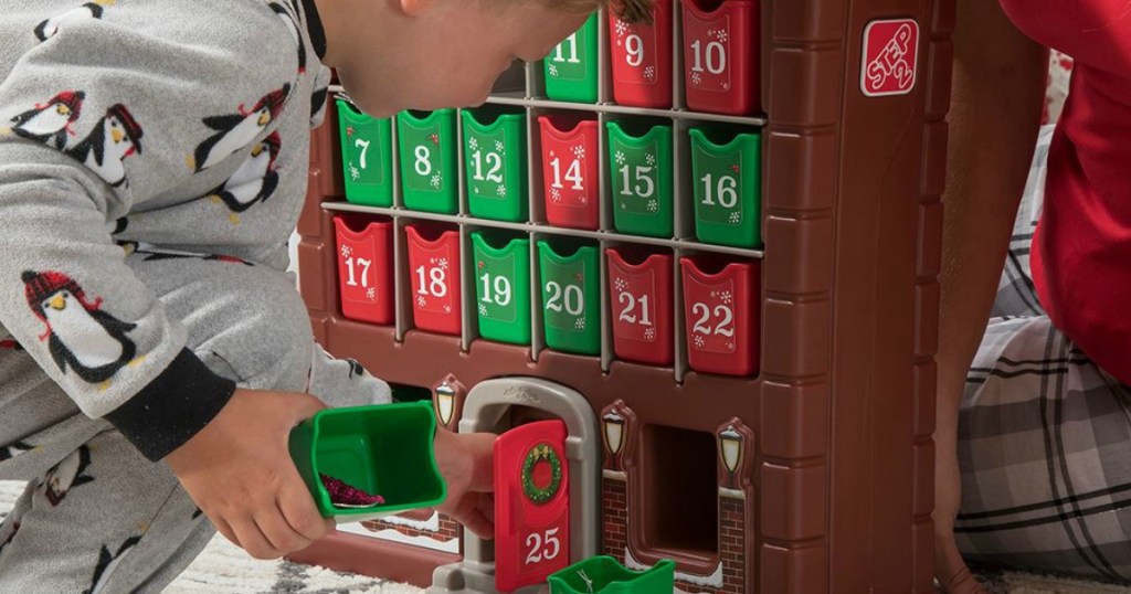 Child playing with a large advent house play set from Step 2