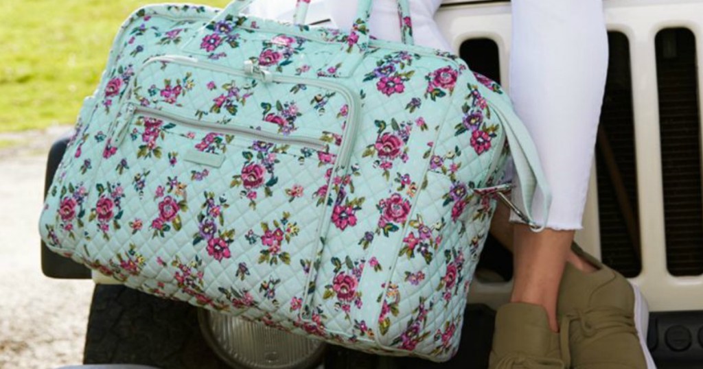 Woman holding Vera Bradley weekender