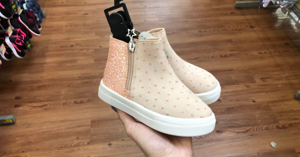 woman holding girls pink wonder nation shoes at walmart