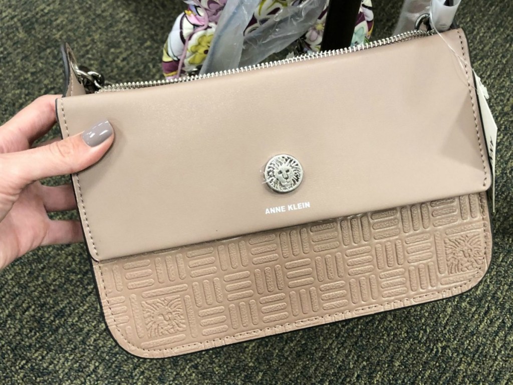 hand holding tan purse