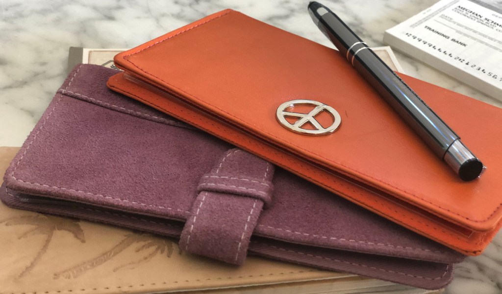 purple and orange checkbooks cover with pen