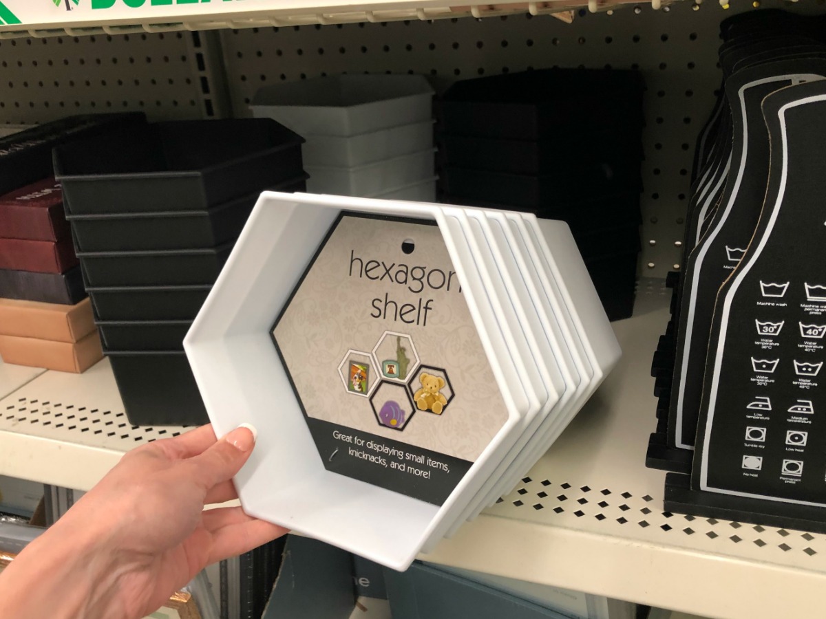 woman holding white hexagon shaped shelf in-store