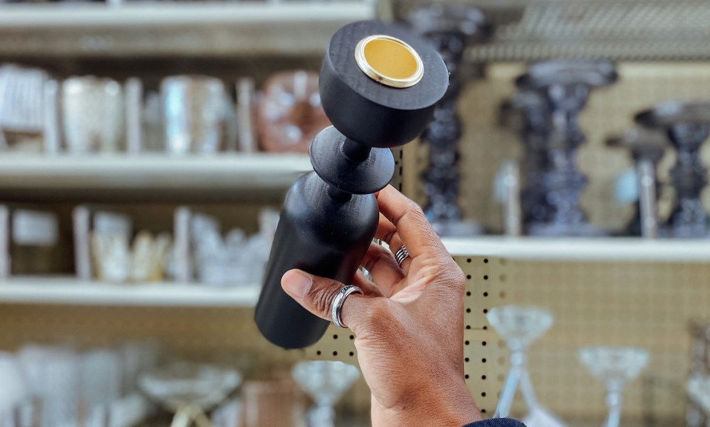 close up of hand holding black candle holder