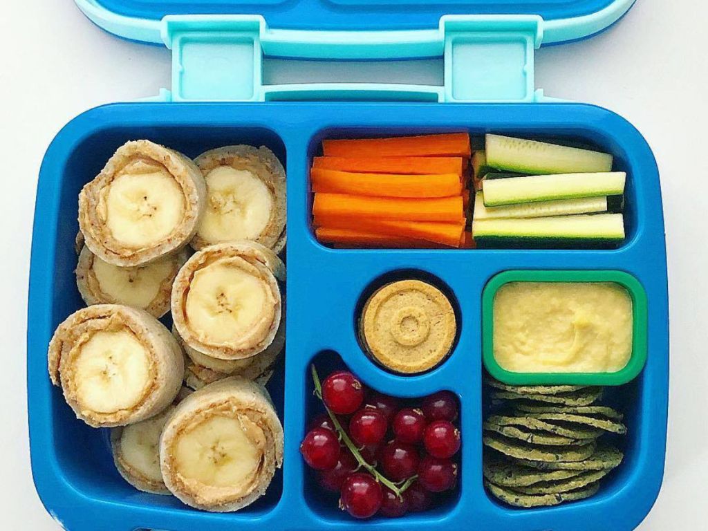 blue kids bentgo box with banana and peanut butter, carrots, grapes, and more