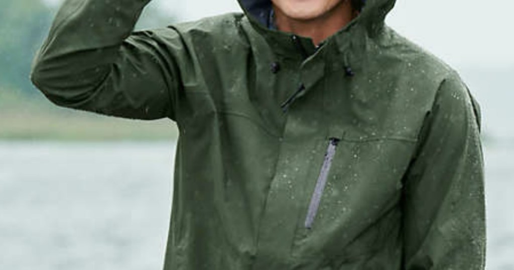 man wearing a green rain jacket outside in the rain